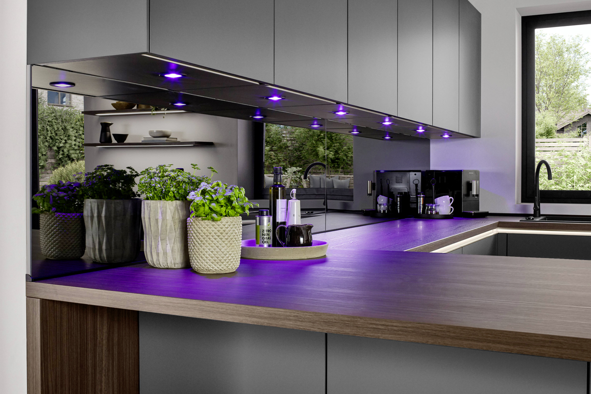 Geschmackvolle Atmosphäre! Die edle Arbeitsplatte in Nussbaumoptik setzt einen warmen Akzent zum Schiefergrau und schafft ein angenehmes Ambiente. Fur die passende Lichtstimmung sorgen die Philips Hue Einbaustrahler, die smart zwischen Arbeitslicht und Wohnlichkeit wechseln.